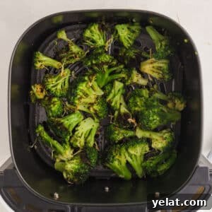 Broccoli in the air fryer topped with parmesan cheese.