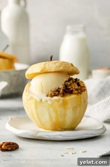 A baked apple with filling and a scoop of ice cream on a plate