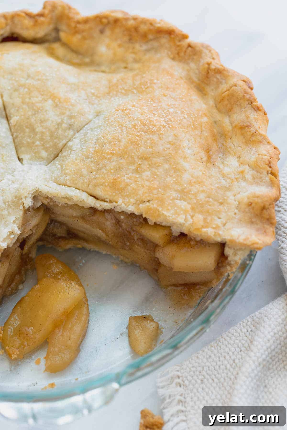 Close up of apple pie in pan with slice cut out