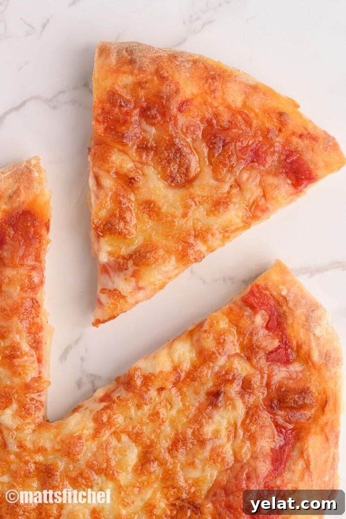 Cutout slice of a low calorie pizza made at home, topped with shredded low fat cheese and tomato sauce