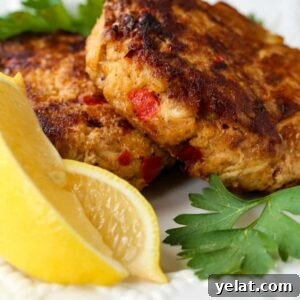 excellent crab cakes on a white plate with sliced lemons