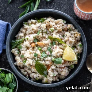 bowl of upma with glass of chai on one side, blue color kitchen towel on another side and curry leaves in the background