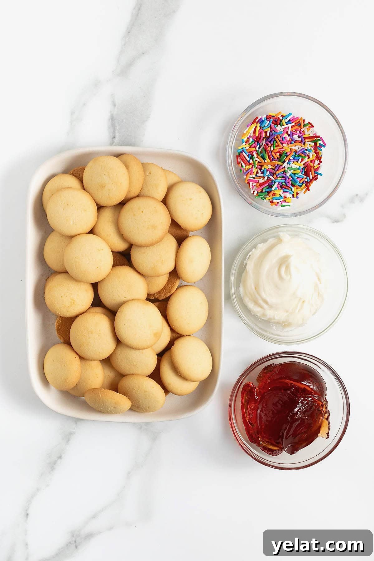 Ingredients to make Nilla wafer pop tarts in small dishes on a white marble counter.