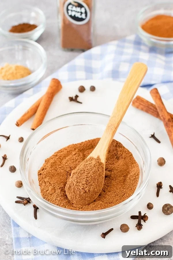 A glass bowl on a white board filled with spices and a spoon.