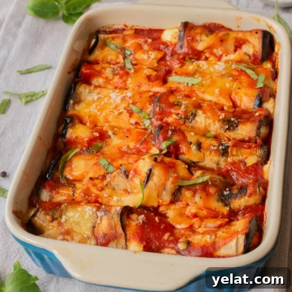 A close up image of eggplant rollatini in a baking dish.