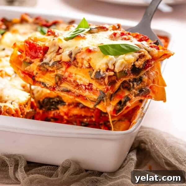 An image of a slice of vegetable lasagna being scooped out of the baking dish.