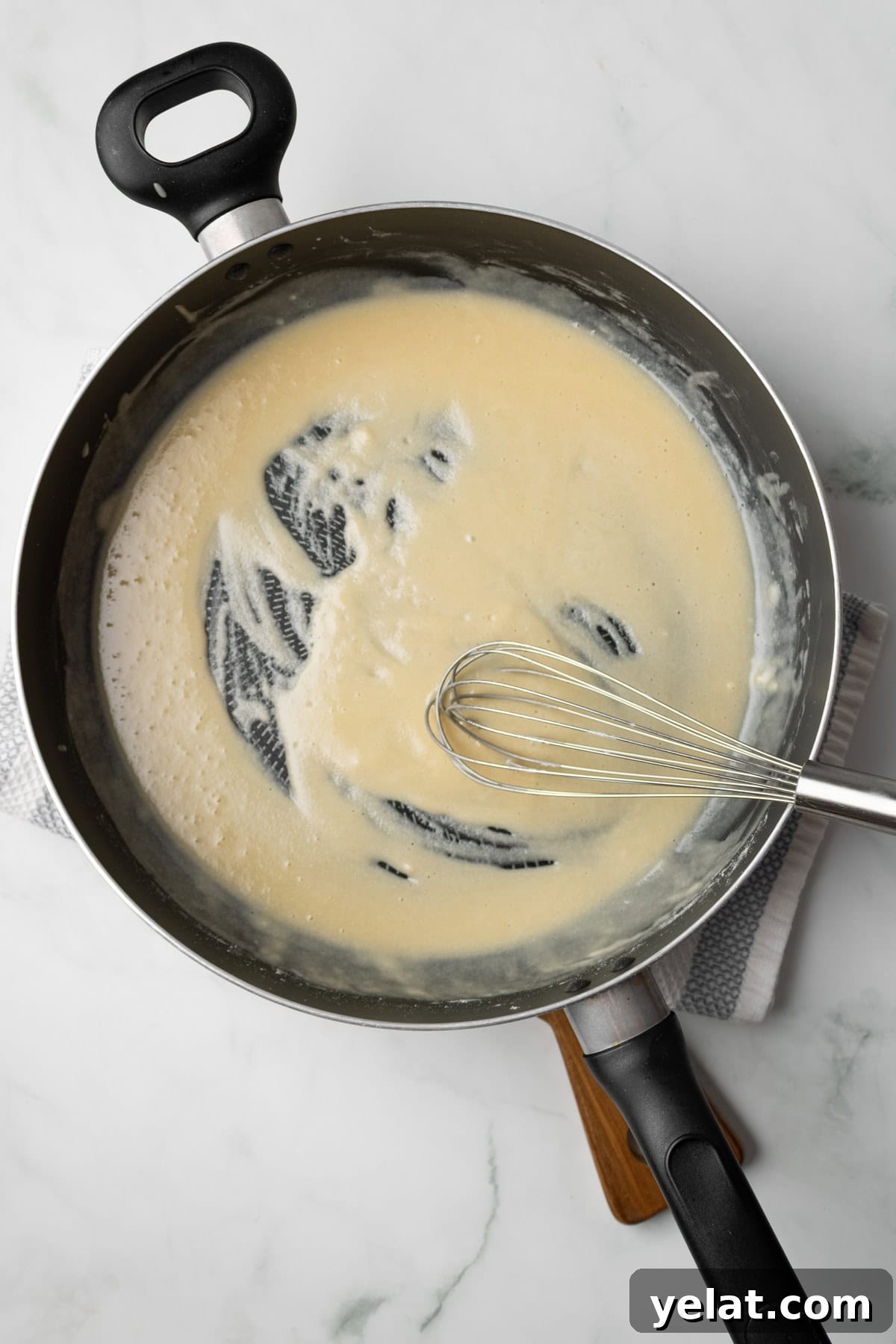 An overhead image of whisking the flour and butter together to make a roux.