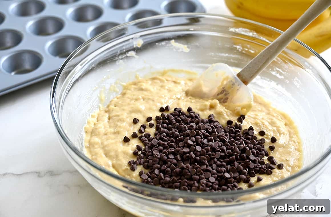 A clear bowl containing batter and mini chocolate chips