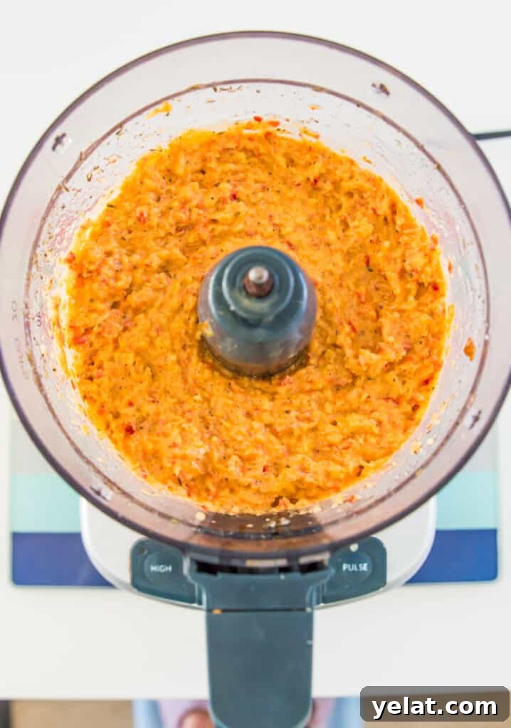 Roasted Red Pepper Cashew-Parsnip Dip (Vegan) 8 A food processor filled with an orange coloured creamy dip.