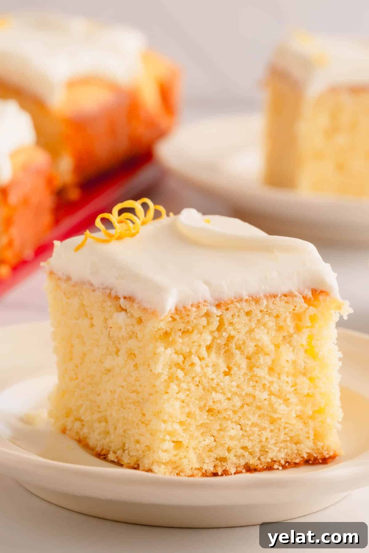 Lemon Sheet Cake Recipe: Zesty, Moist Lemon Cake for Large Groups 2 A slice of lemon sheet cake topped with lemon cream cheese icing.