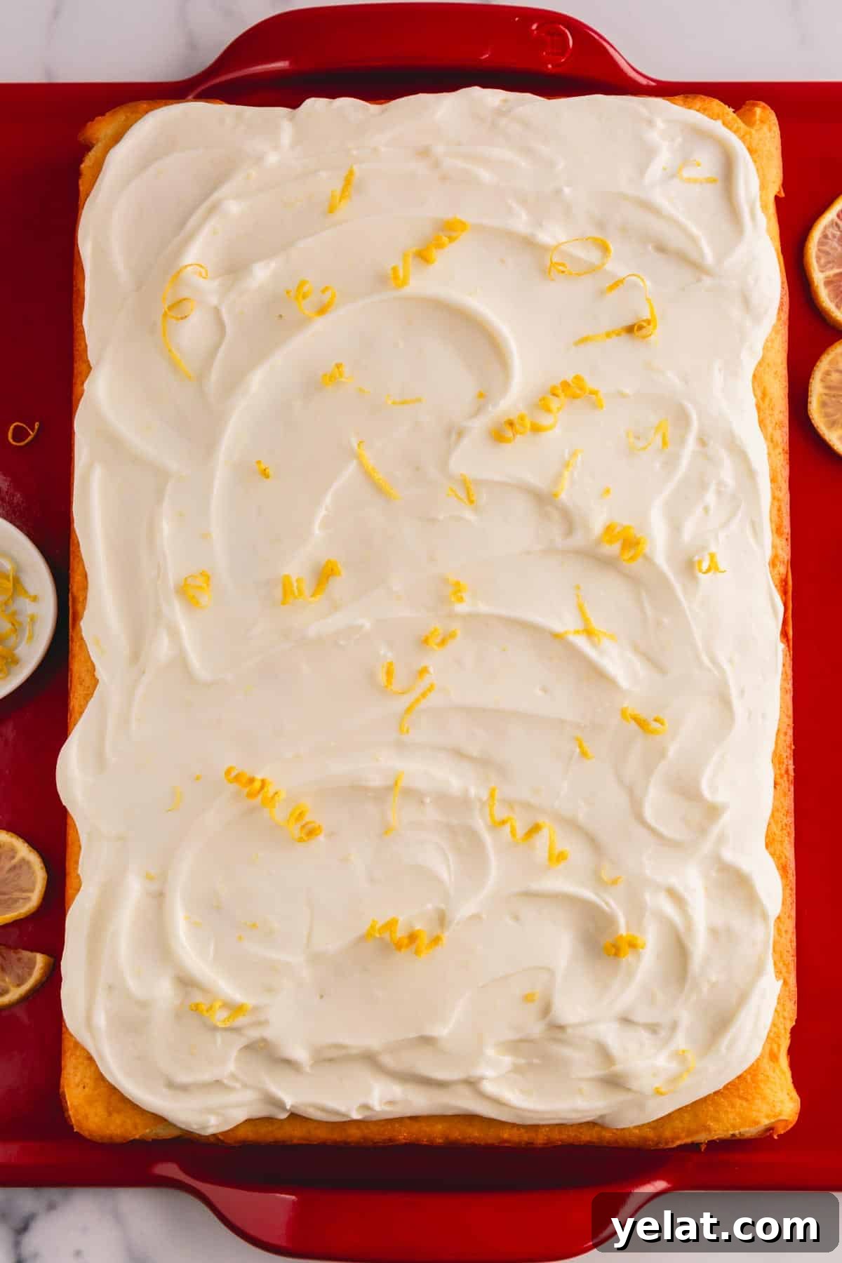 Lemon Sheet Cake Recipe: Zesty, Moist Lemon Cake for Large Groups 12 A lemon cream cheese cake topped with lemon cream cheese frosting and lemon zest.