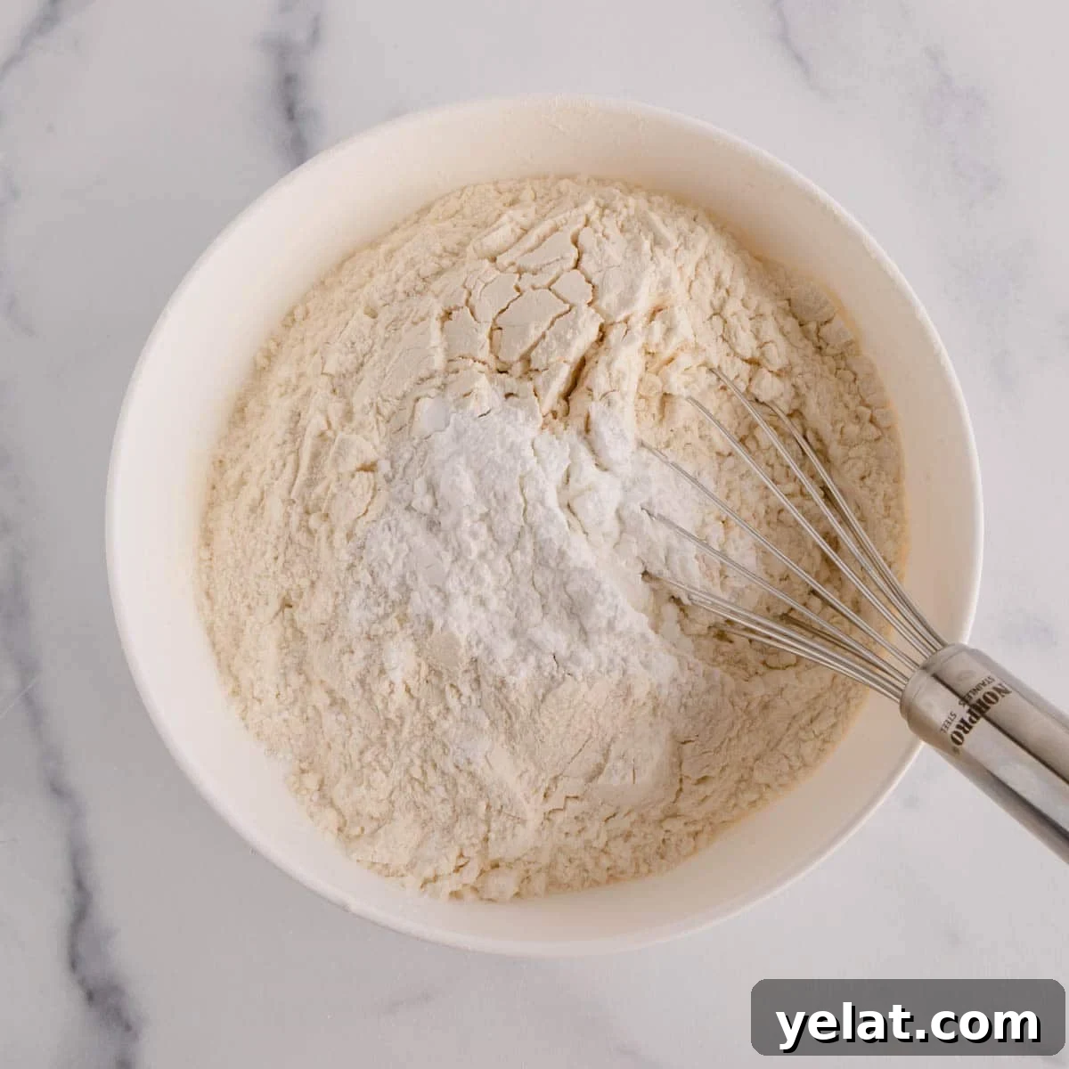 Lemon Sheet Cake Recipe: Zesty, Moist Lemon Cake for Large Groups 5 Dry ingredients for lemon sheet cake being whisked in a bowl.