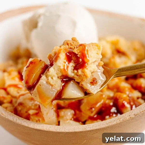 Rustic Plum & Apple Crumble Recipe for Fall Baking 17 Spoonful of pear crumble being lifted from bowl.