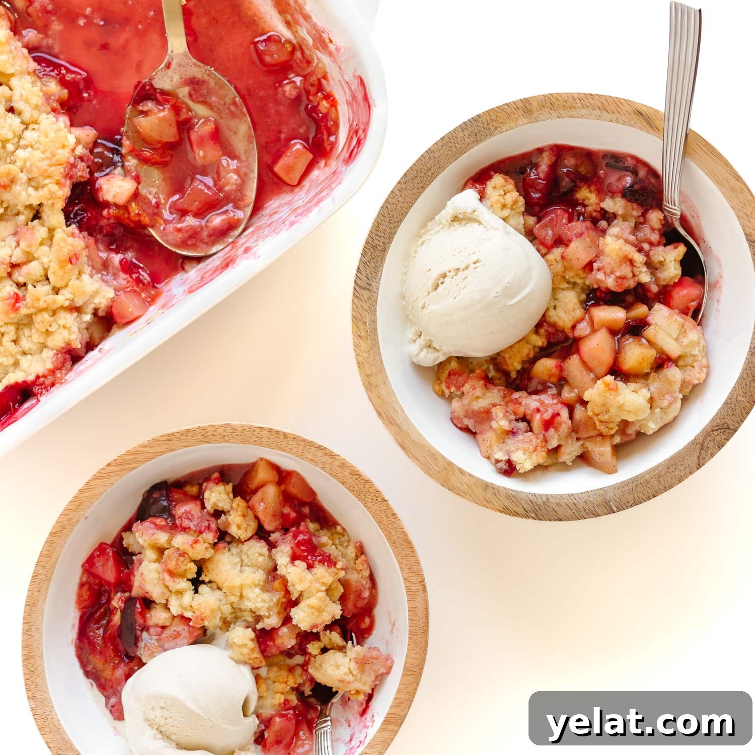 Rustic Plum & Apple Crumble Recipe for Fall Baking 9 Plum apple crumble being served into two bowls with a scoop of vanilla ice cream.