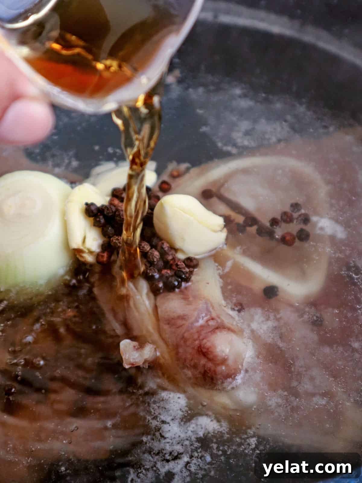 pouring fish sauce in a pot of boiling beef shanks