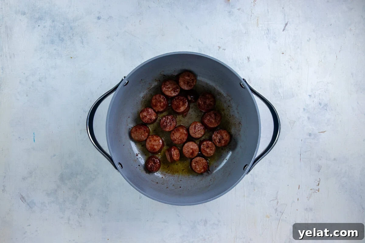 Cajun Sausage Spaghetti Recipe: Spicy Pasta with Andouille 4 Cut up sausage browned in a pot.