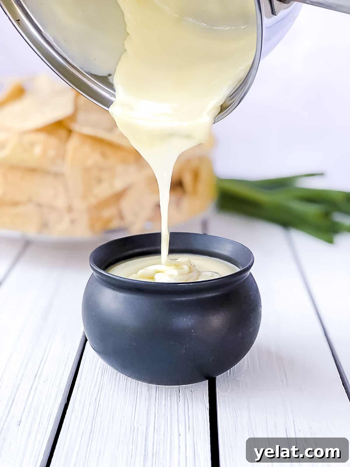 White cheese sauce without flour being poured into mini crock.