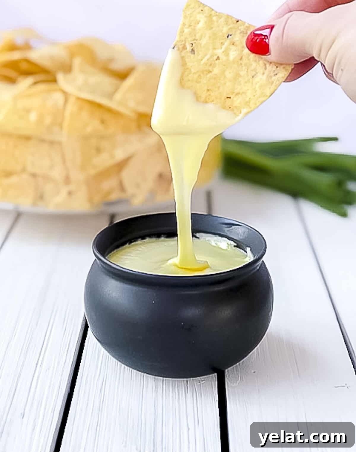 Dipping tortilla chip into flourless white cheese sauce.