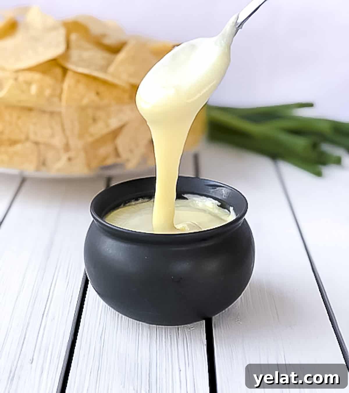 Spoon being dipped into flourless white cheese sauce.