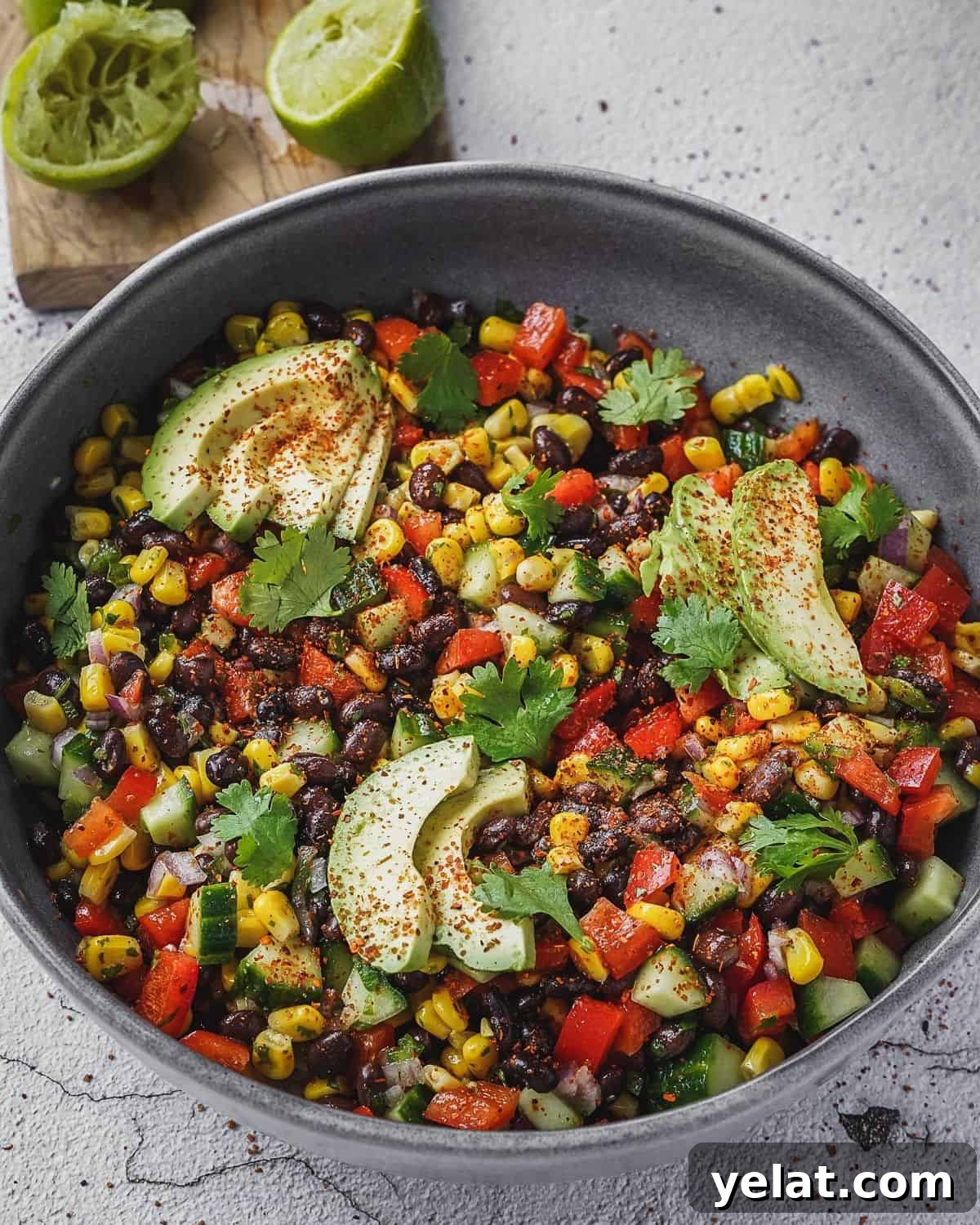 Fiesta salad with corn, beans, peppers and cilantro in a bowl with avocado.