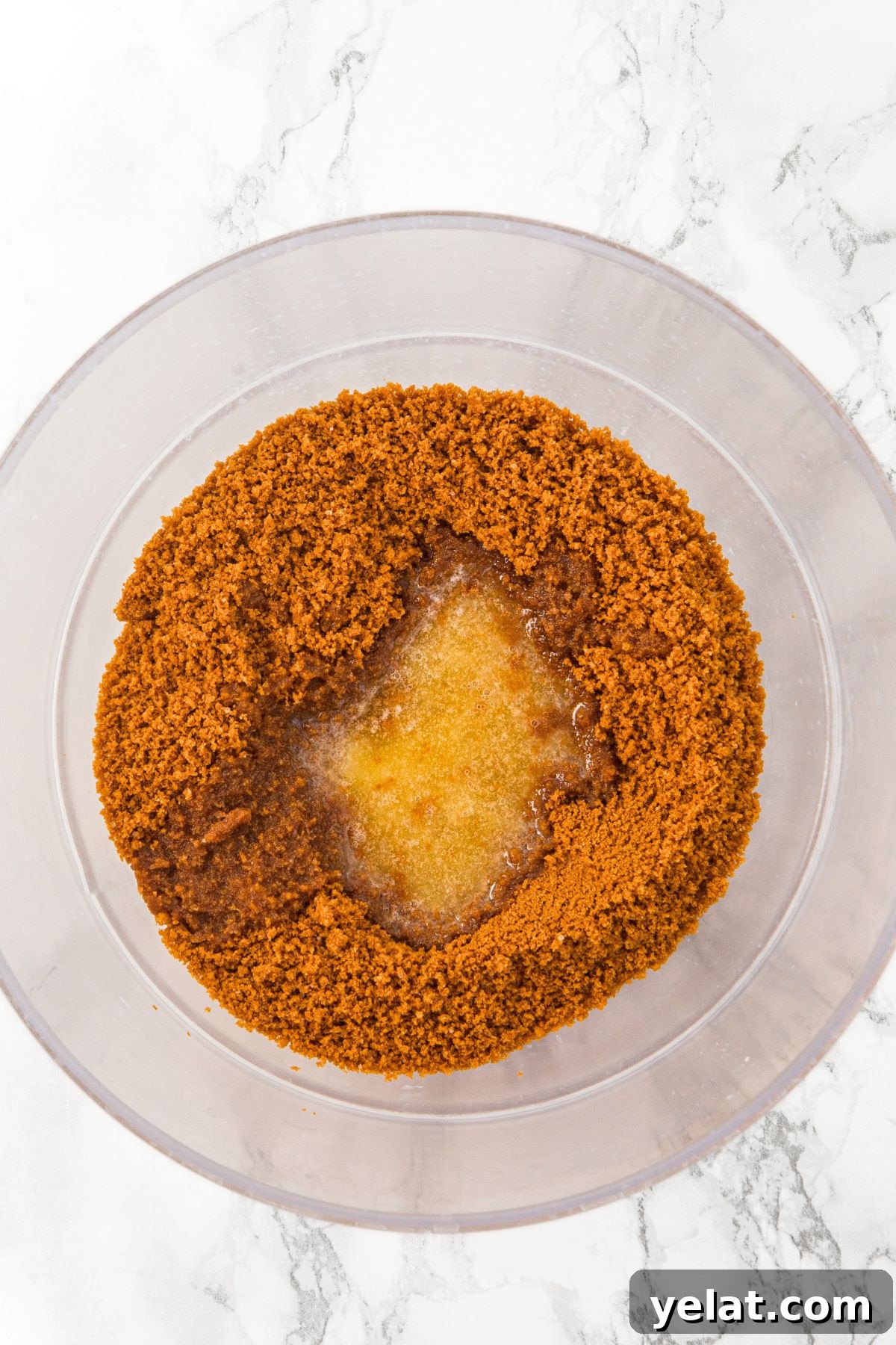 Gluten-Free Mini Gingerbread Cheesecakes Graham crackers crumbs and melted butter in bowl