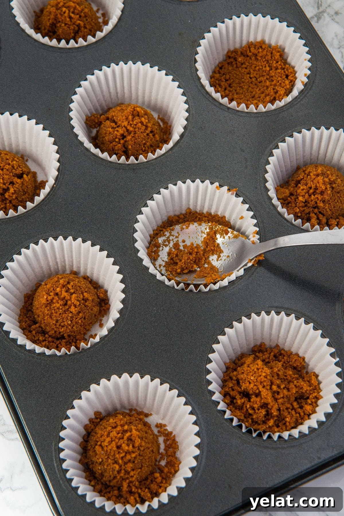 Gluten-Free Gingerbread Cheesecake Recipe Pressing graham cracker crumbs into muffin liners