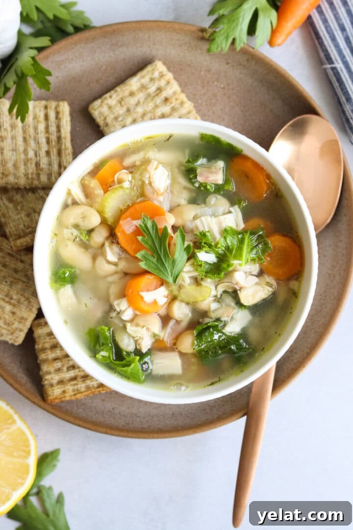 Hearty White Bean and Chicken Soup with Garlic and Herbs 3 Overhead photo of a white bowl filled with chicken and white bean soup