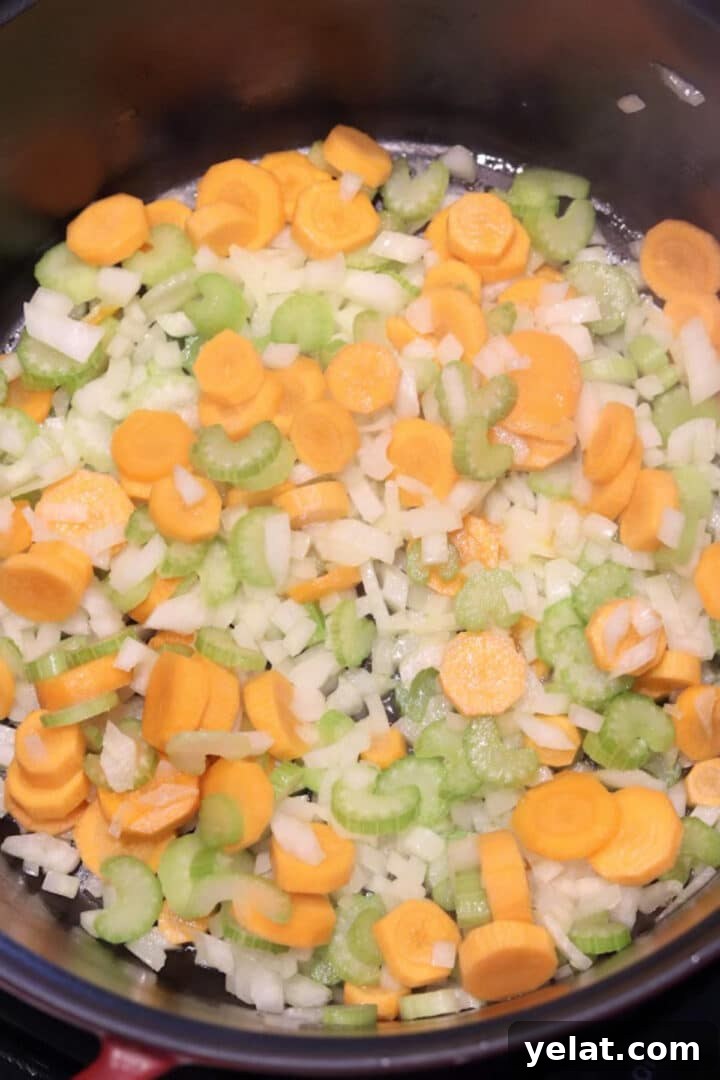Hearty White Bean and Chicken Soup with Garlic and Herbs 6 Mirepoix stirred and cooking in a large dutch oven