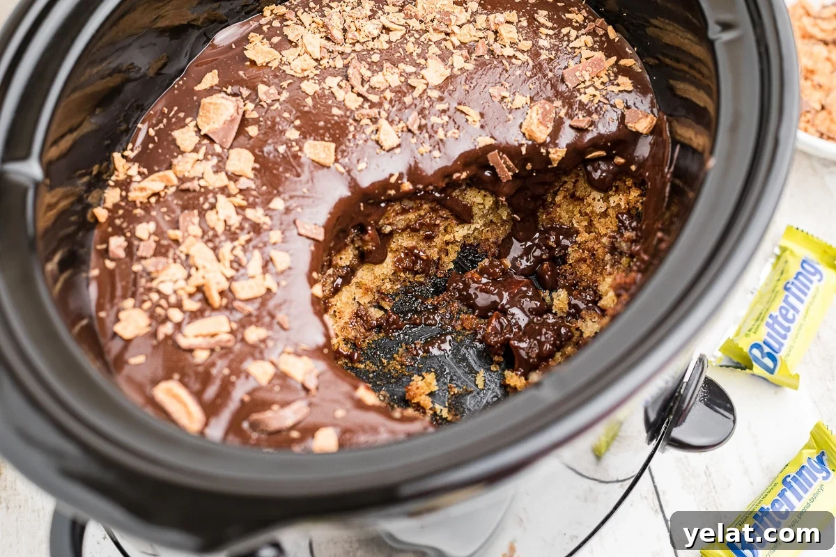 Slow Cooker Butterfinger Dessert Cake Recipe 6 scoop taken out of butterfinger cake in slow cooker.