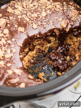 Slow Cooker Butterfinger Dessert Cake Recipe 8 scoop taken out of butterfinger cake in slow cooker.
