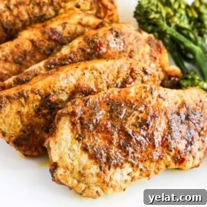 Crispy Oven-Baked Boneless Pork Chops with Garlic Herb Rub 5 Five cooked jerk lime boneless pork chops overlapping each other one a white plate with broccoli to the right.