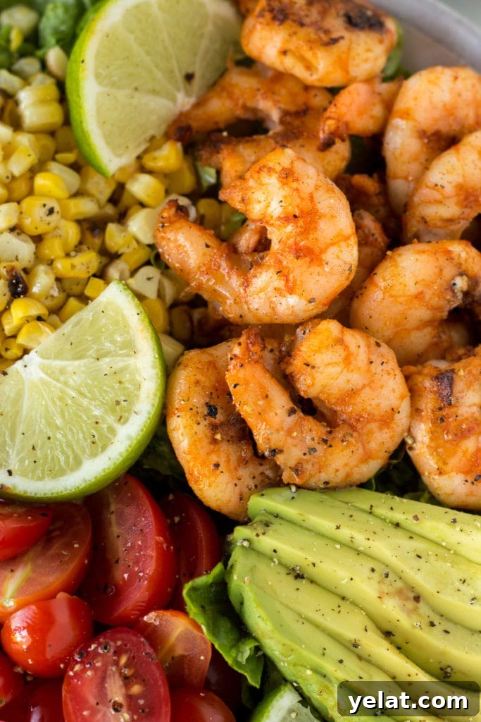 Grilled Shrimp, Avocado & Corn Salad with Lime Vinaigrette 4 Close up of grilled shrimp and corn salad with tomatoes, lime, and avocado slices.