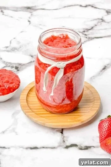 A glass jar filled with homemade strawberry jam.