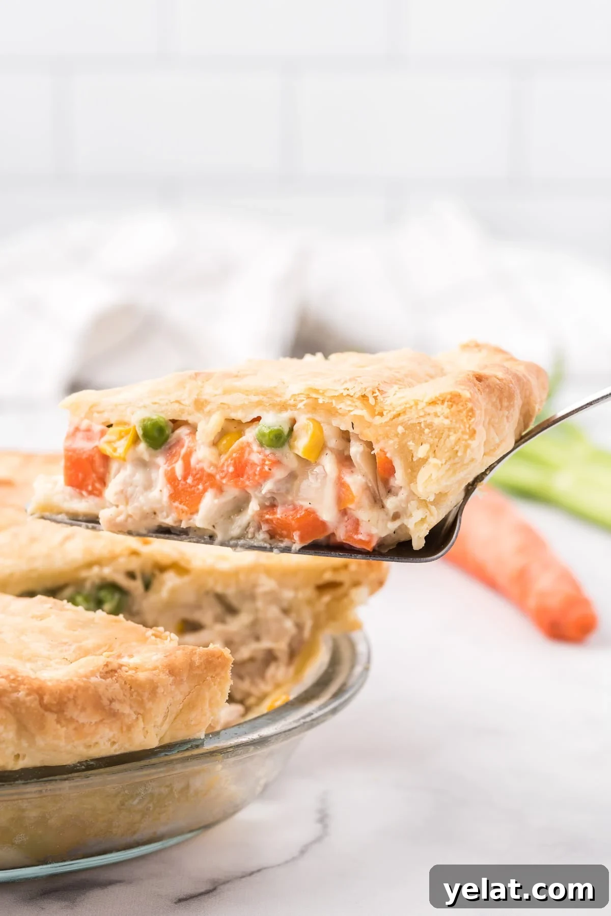 Image of a single slice of chicken pot pie being removed from the whole pie.