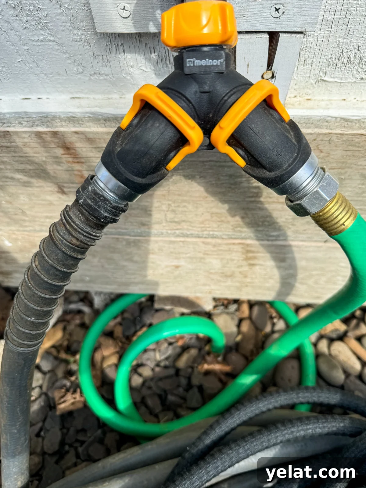 2-Way hose valve with orange levers in the garden