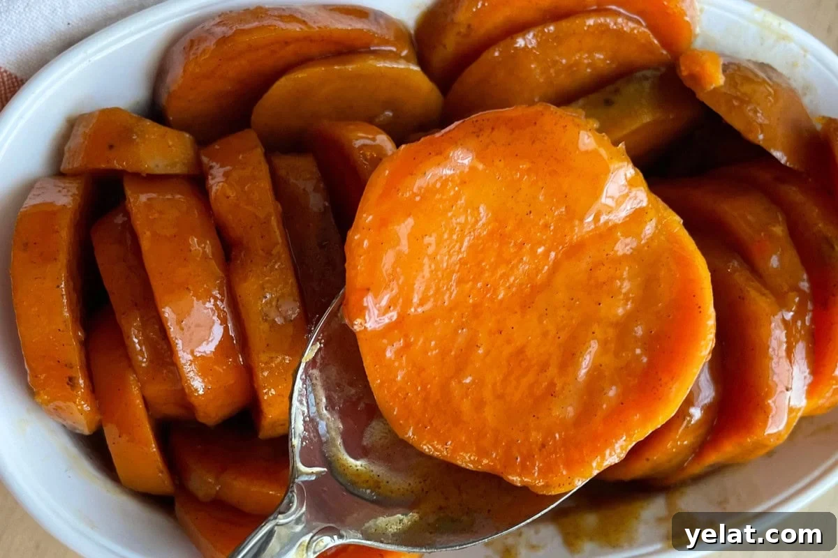 12 Crowd-Pleasing Easter Crockpot Recipes for a Stress-Free Holiday 13 A close-up of glazed candied sweet potatoes in a white dish.