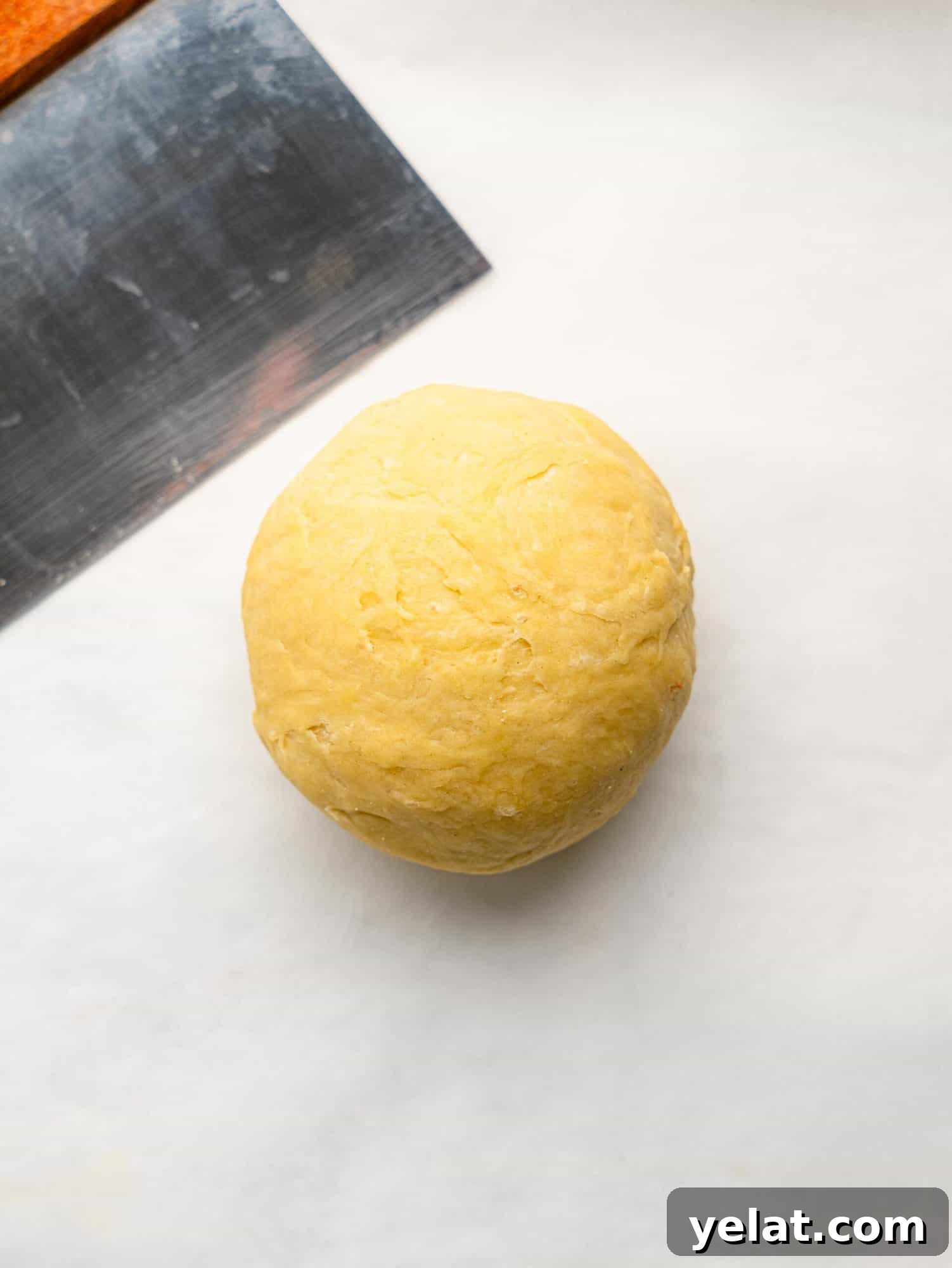 Easy empanada dough ball on a sheet of parchment paper.