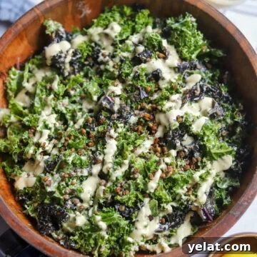 overhead view of a wooden bowl with homemade vegan caesar with lentils, tofu dressing, and massaged kale.