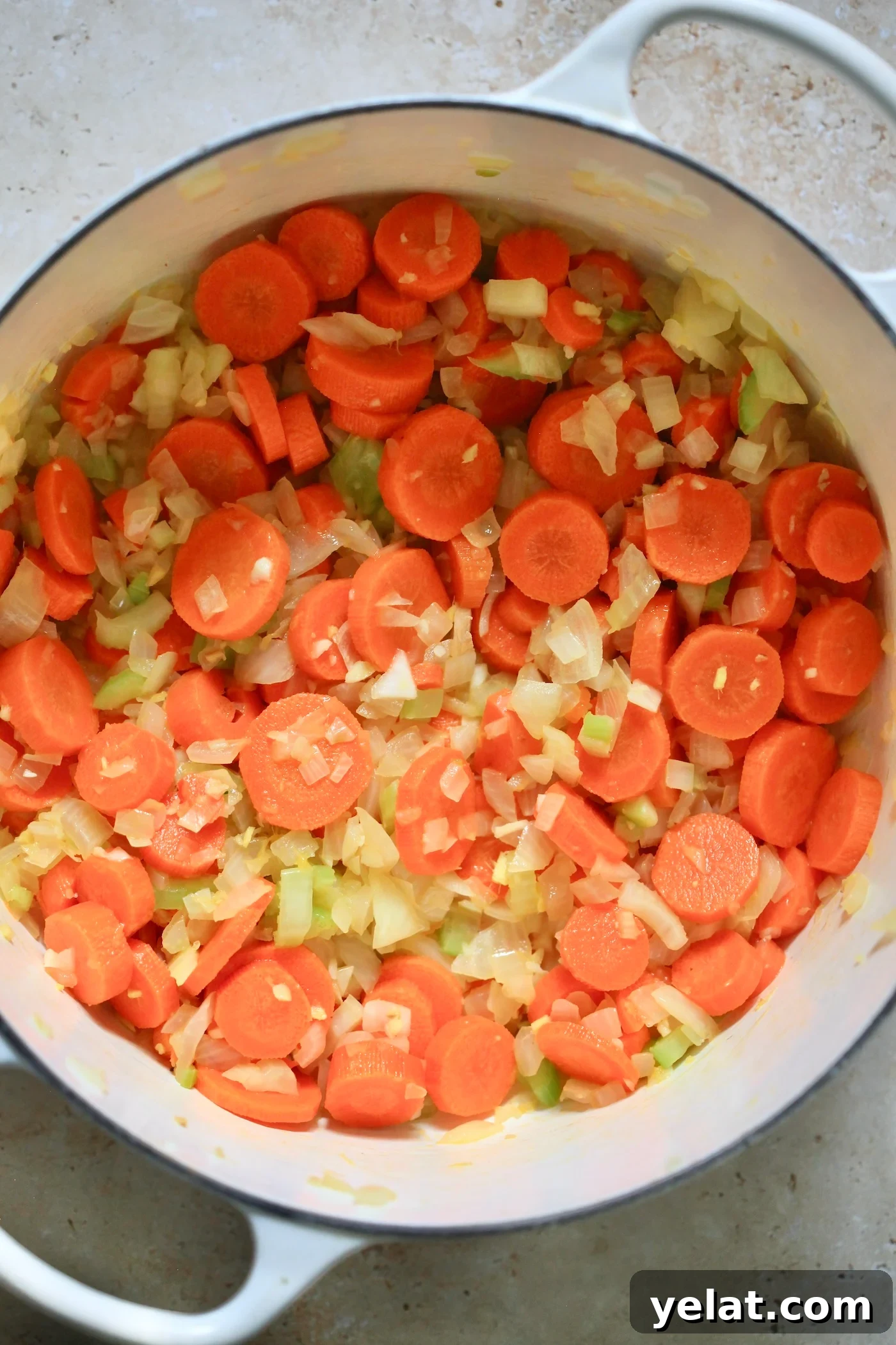Hearty Carrot and Red Lentil Soup Recipe for Comfort and Flavor 3 onion, carrot and celery in pot.
