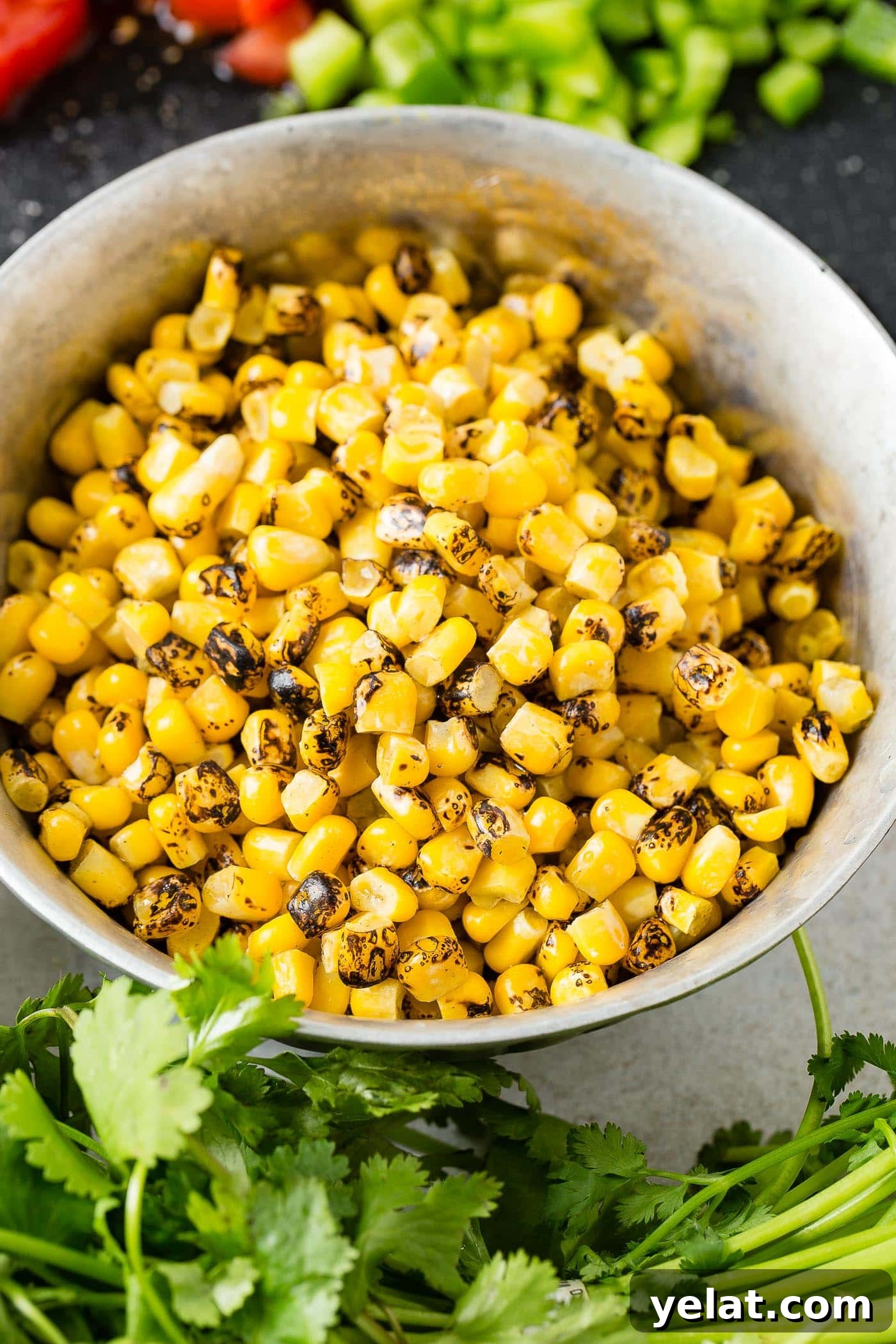 Tex-Mex Chopped Ground Beef Taco Salad Recipe 7 A bowl of roasted corn with cilantro leaves scattered around the bowl.