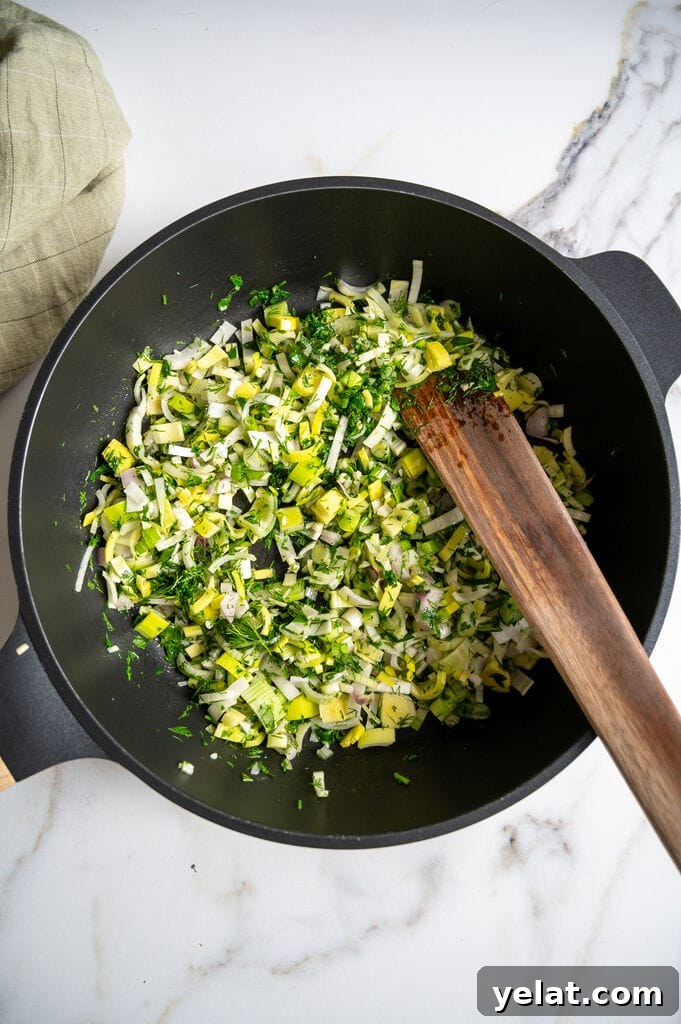 Sautéing the spinach with the leek, shallots and garlic.