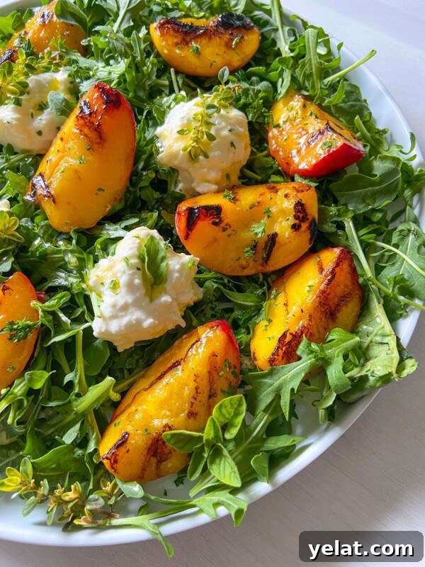Polish Strawberry Pasta Recipe: Sweet Summer Noodles with Strawberries 7 A Peach Burrata Salad featuring fresh arugula, grilled peach slices, creamy cheese dollops, and a garnish of herbs and edible flowers.