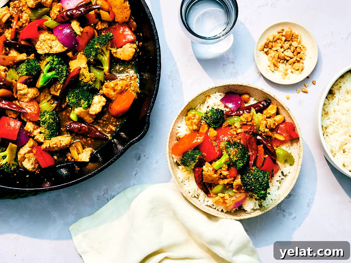 Spicy Kung Pao Tofu with Stir-Fried Vegetables 3 Kung Pao Vegetables, Tofu, and peanuts in a skillet and bowl on a dinner table.
