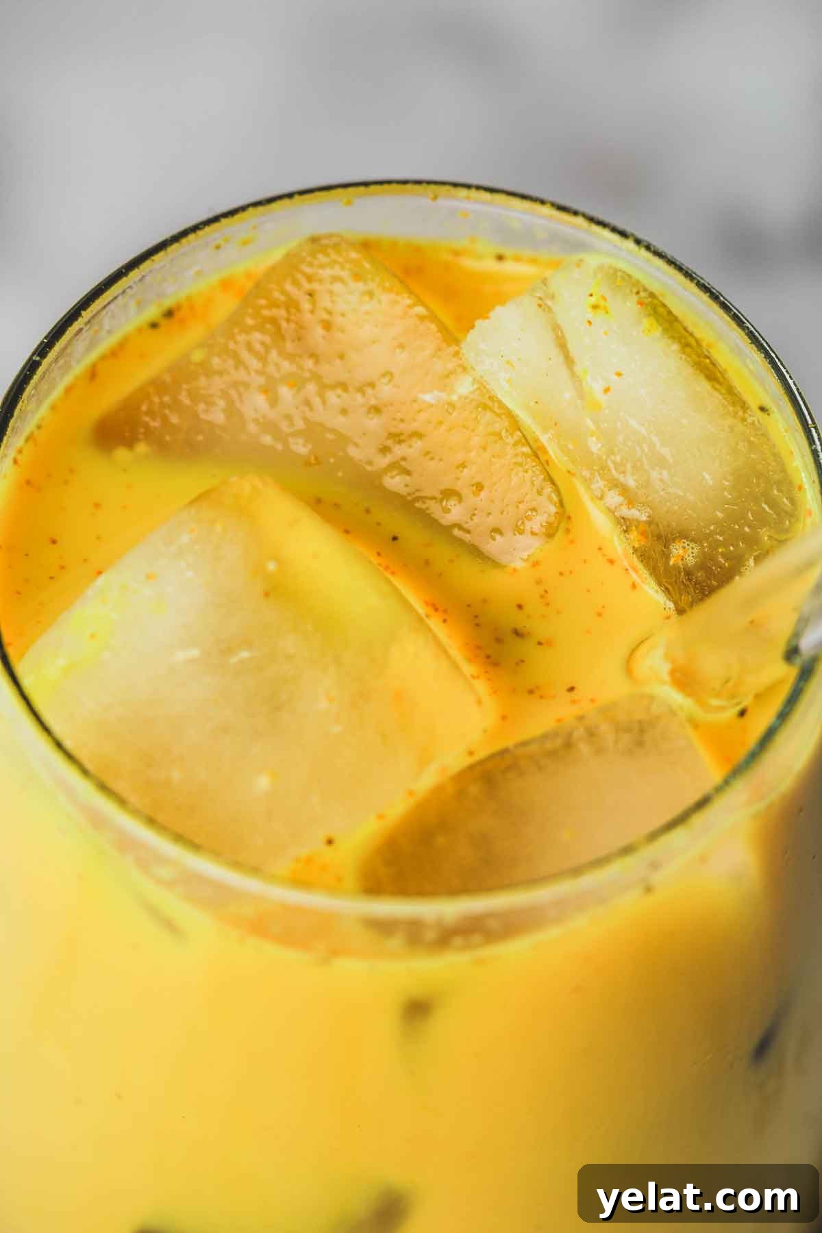 Iced Turmeric Golden Milk Recipe for Refreshing Wellness 12 verre avec du lait au curcuma et des glaçons