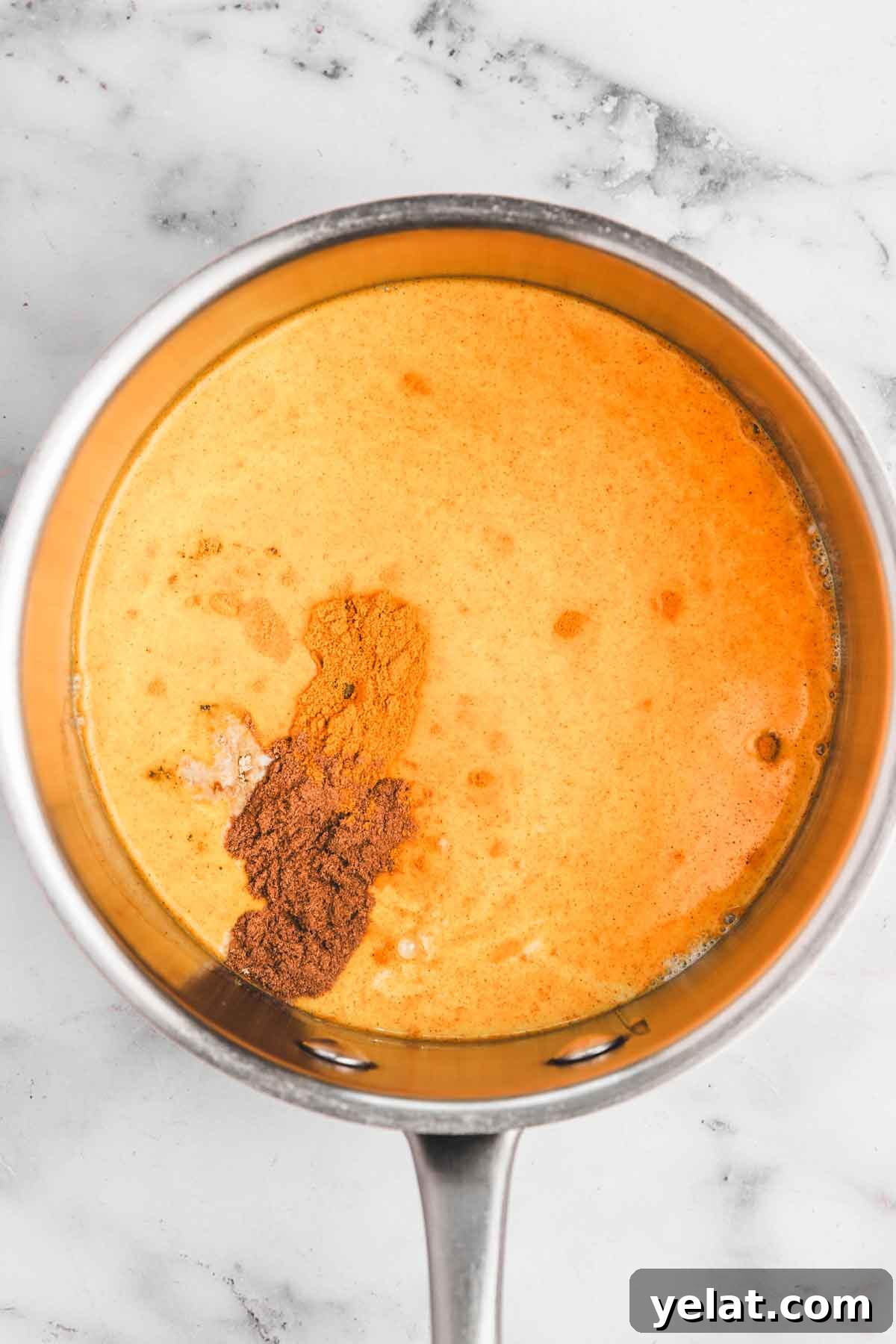 Iced Turmeric Golden Milk Recipe for Refreshing Wellness 4 casserole avec du lait et des épices