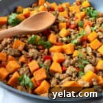 Closeup of Turkey Hash with Sweet Potatoes with a wooden spoon.