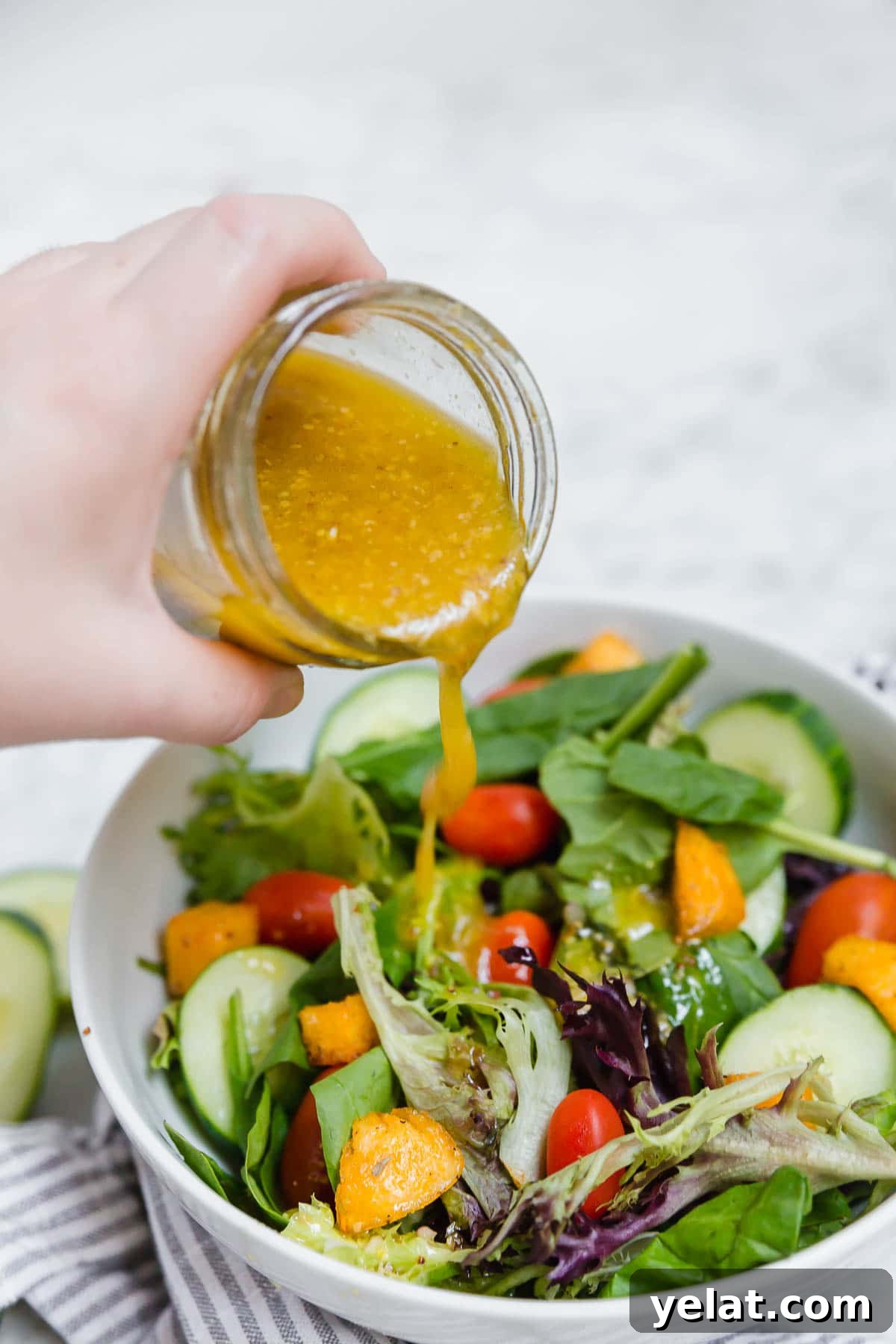 Creamy Honey Mustard Vinaigrette Recipe for Salads & Marinades 3 Gluten-Free honey mustard vinaigrette being poured onto a colorful salad.