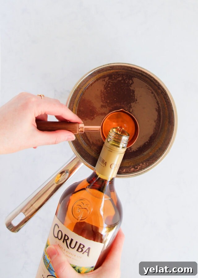 Homemade Rum Caramel Sauce Recipe for Desserts and Drizzling 11 The rum being added to the caramel.