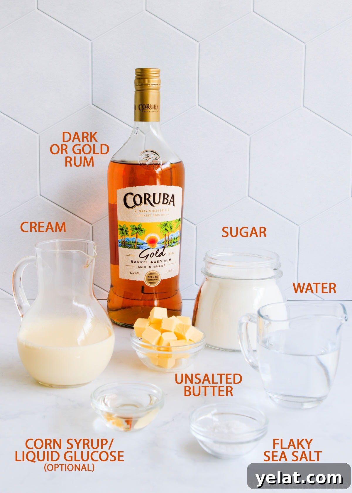 Homemade Rum Caramel Sauce Recipe for Desserts and Drizzling 4 Rum caramel sauce ingredients on a grey background with orange text labels - rum, sugar, crea, water, butter, corn syrup and salt.