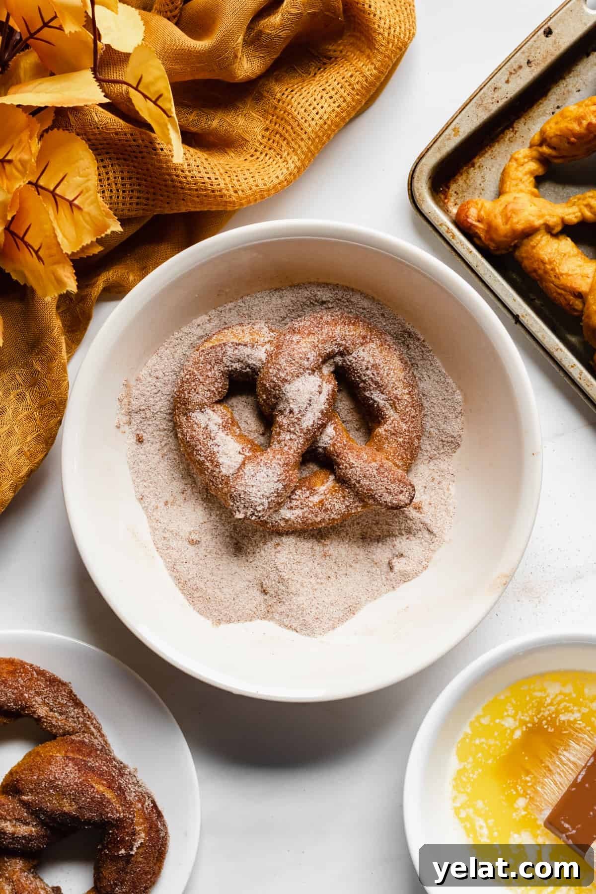 Finished pretzel being rolled in pumpkin spice sugar